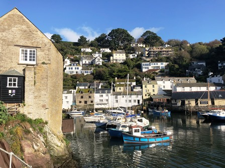 A Cornish fishing village of white cottages rising steeply above a sheltered inner harbour