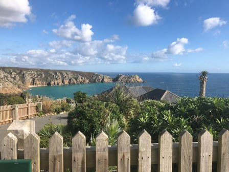 View from a Cornish clifftop garden across granite headlands to a deep blue bay
