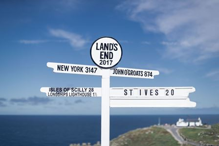 The white Cornish coastal signpost pointing out distances across the sea